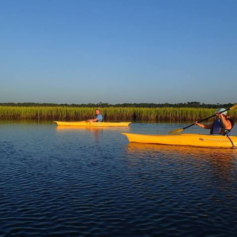 Two kayakers paddling through the marsh lands of Myrtle Beach, SC