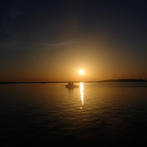 Vignette of two kayakers paddling toward sunset in Myrtle Beach, SC