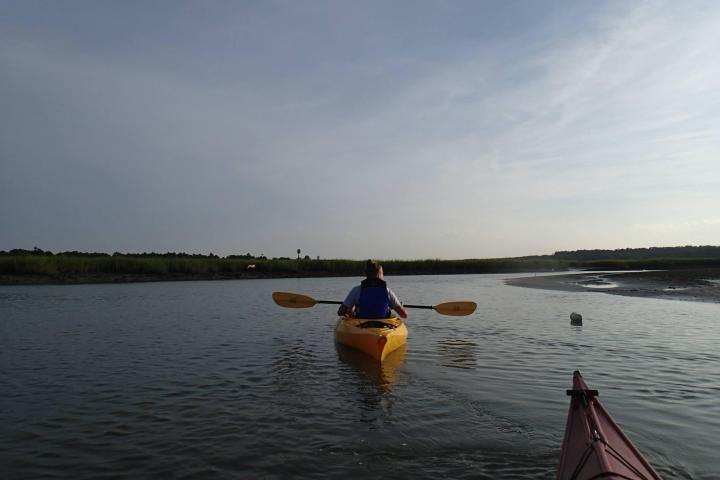 A kayaker paddling through a salt marsh in Myrtle Beach, SC