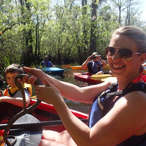 Kayakers on river holding snake